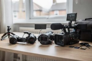 Videokamera in den Händen eines Filmemachers beim Aufnehmen einer Outdoor-Szene.