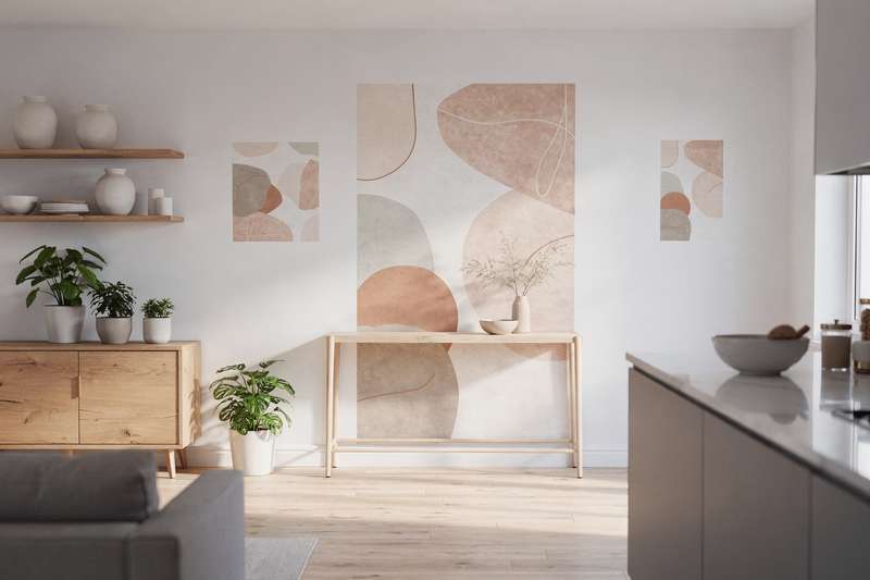 Frau bringt mit Rakelwerkzeug ein großflächiges Wandtattoo in modernem geometrischem Design an einer hellen Wohnzimmerwand an.
