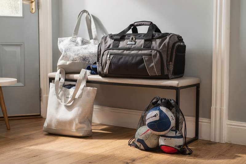 Sportlerin trägt eine gepolsterte Netball-Tasche mit Schultergurt über dem Arm zu ihrem Training.
