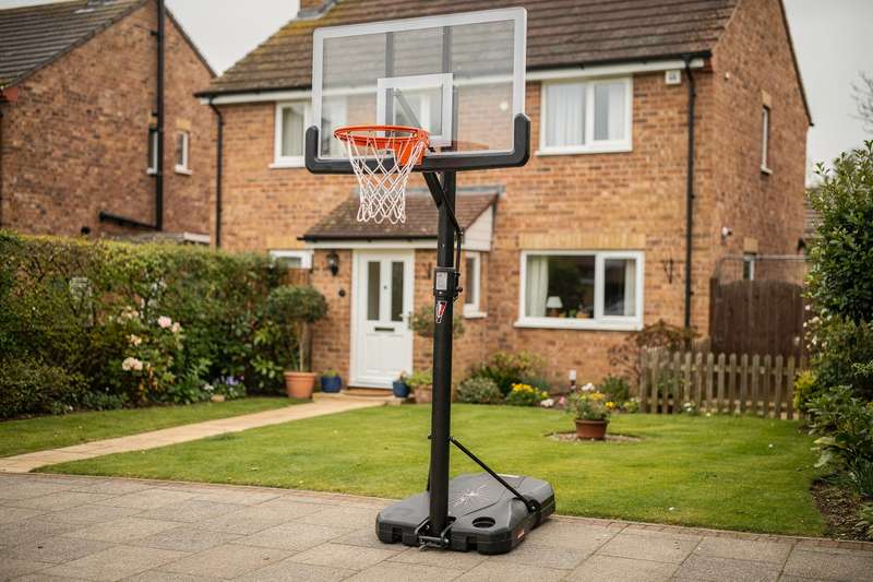 Zwei Hände greifen nach einem Basketball, der gegen eine Wandhalterung prallt.