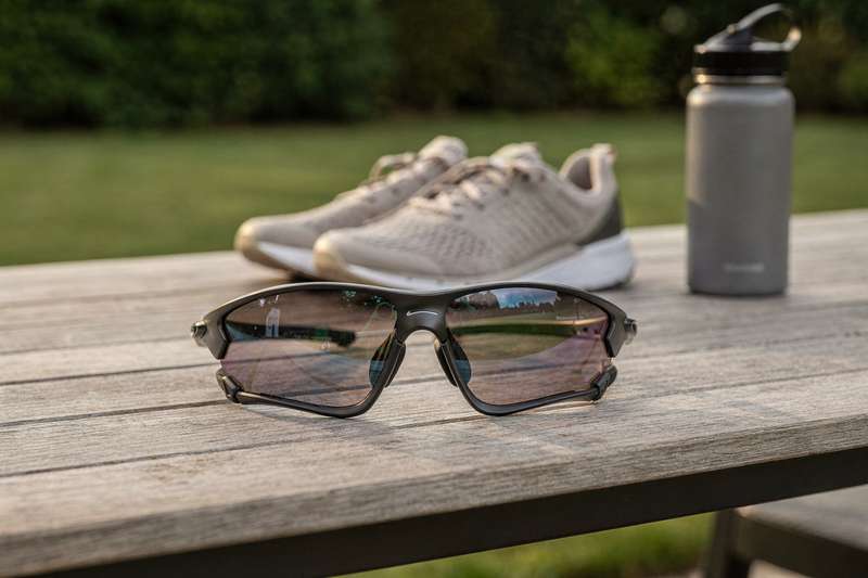 Sportler trägt eine Sonnenbrille beim Joggen in der Sonne und schützt seine Augen vor UV-Strahlung.