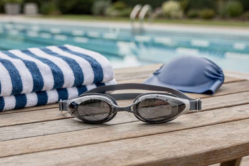 Schwimmer trägt eine moderne Schwimmbrille beim Freiwasserschwimmen in einem See.