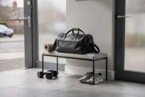 Eine Frau packt ihre Sporttasche mit Trainingskleidung und Schuhen für das Fitnessstudio.