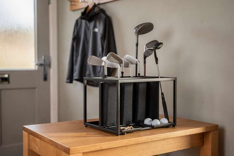 Golfspieler sortiert seine Schläger und Accessoires in einem praktischen Organizer vor dem Abschlag.